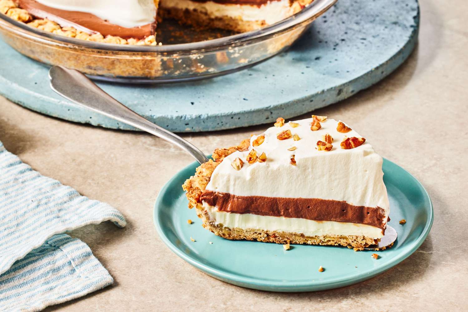 a slice of Arkansas Possum Pie on a plate with a fork, full pie in the background