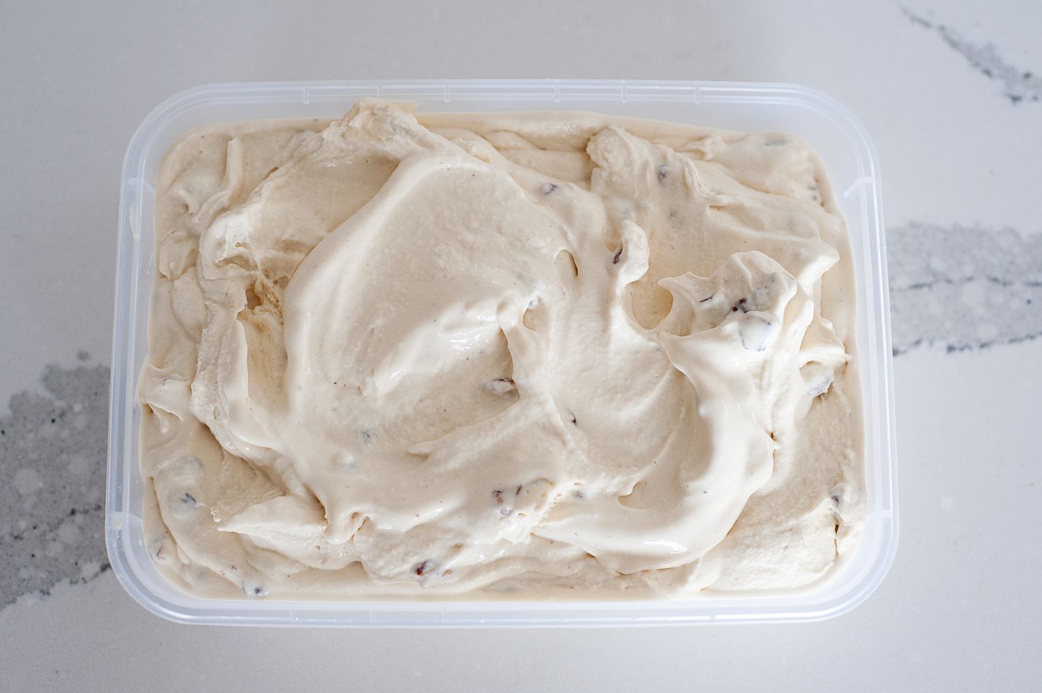 Freezing butter pecan ice cream in a freezer safe container.