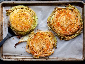 Overhead view of roasted cabbage steaks on a baking sheet.