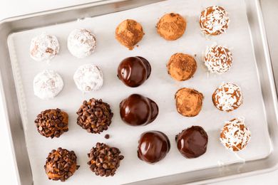 Overhead view of sheet of rum balls from Granny's Rum Balls recipe with various coatings and placed on a baking sheet with parchment paper