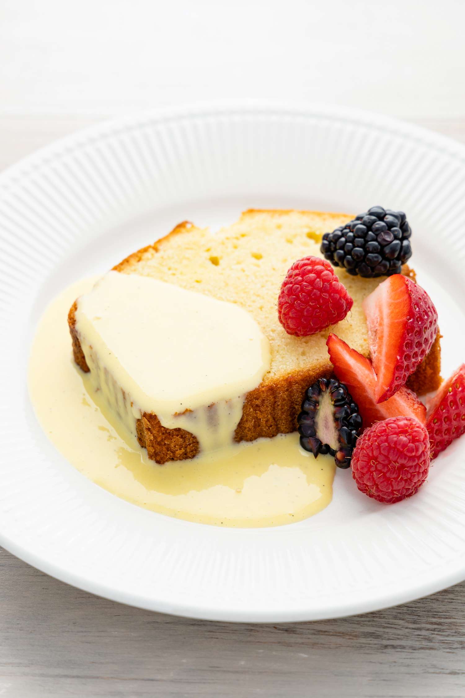 Plate with a Piece of Pound Cake Covered with Creme Anglaise and Fruits