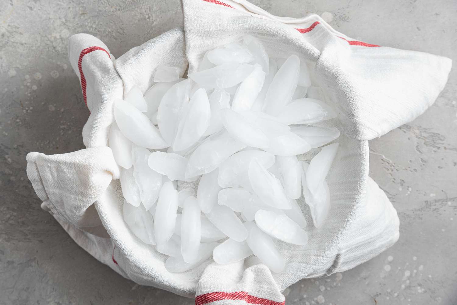 Ice in a kitchen towel covering a bowl