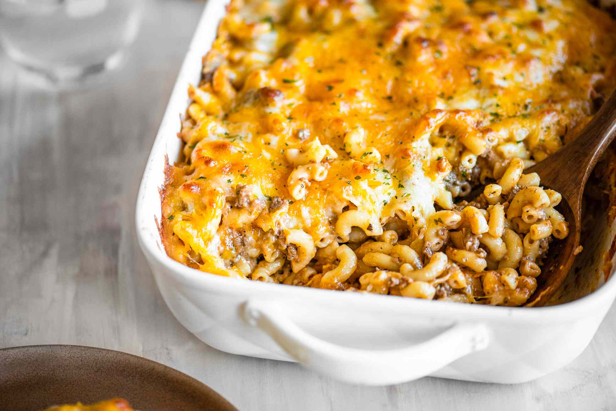 Casserole Dish of Cheeseburger Casserole with a Serving Already Served Using a Spoon