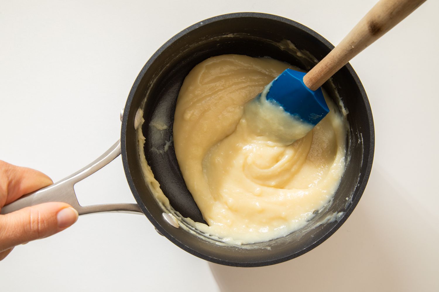 Tangzhong slowly forming in the saucepan while mixed using a spatula for salted honey rolls recipe