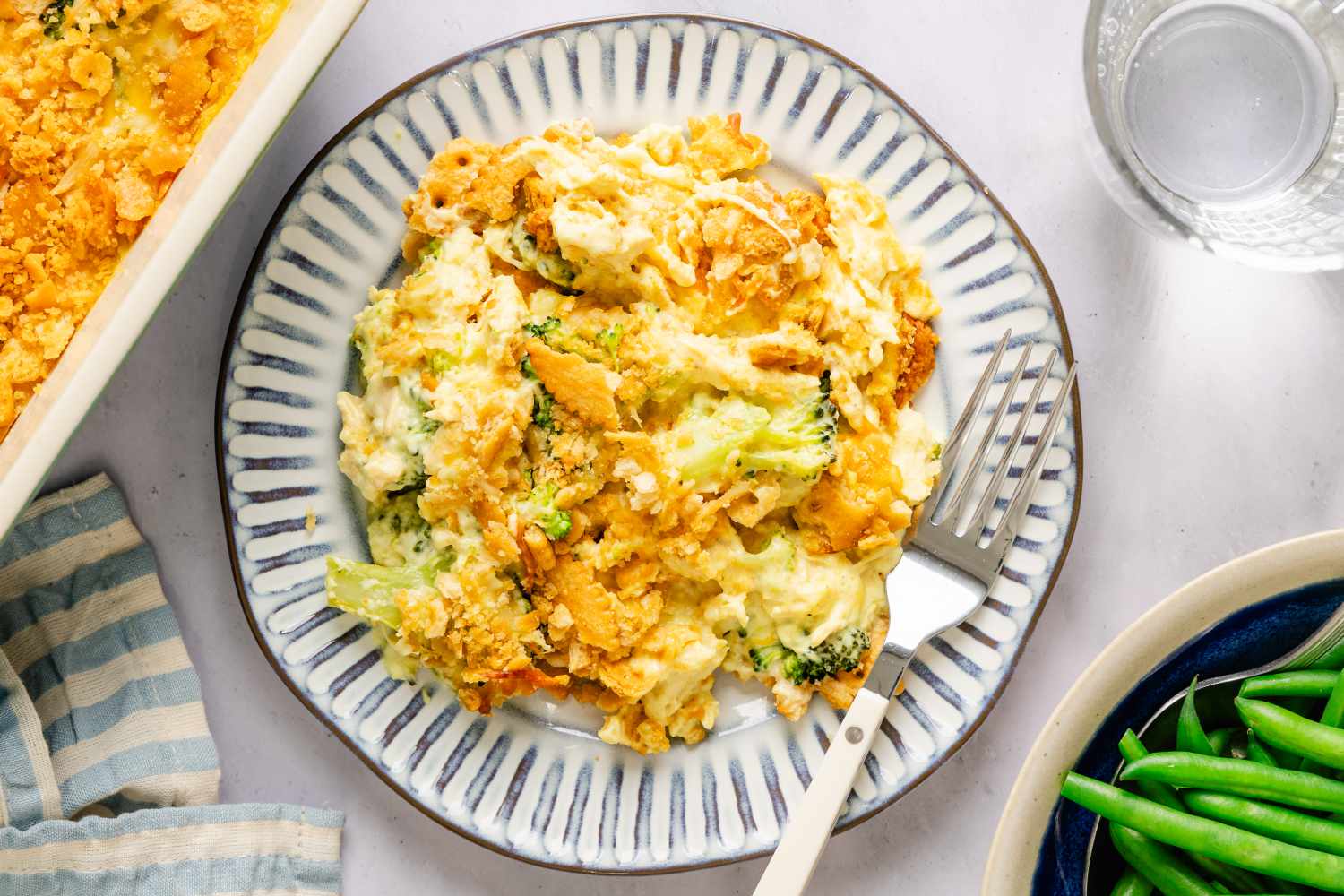 Chicken Divan casserole served on a plate with a fork a creamy chicken and broccoli dish with a crunchy topping