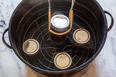 Adding Cans to Pot of Water for Bath Canning Method 