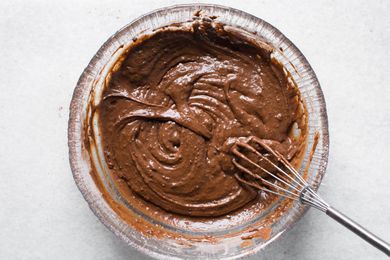 Chocolate batter in a glass bowl with a whisk