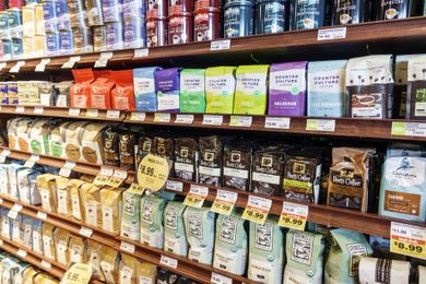 Shelves stocked with various coffee brands in a grocery store