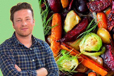 Jamie Oliver next to a pan of roasted vegetables including beets, carrots, and Brussels sprouts