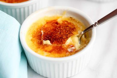 Crème Brûlée in a white ramekin with a spoon