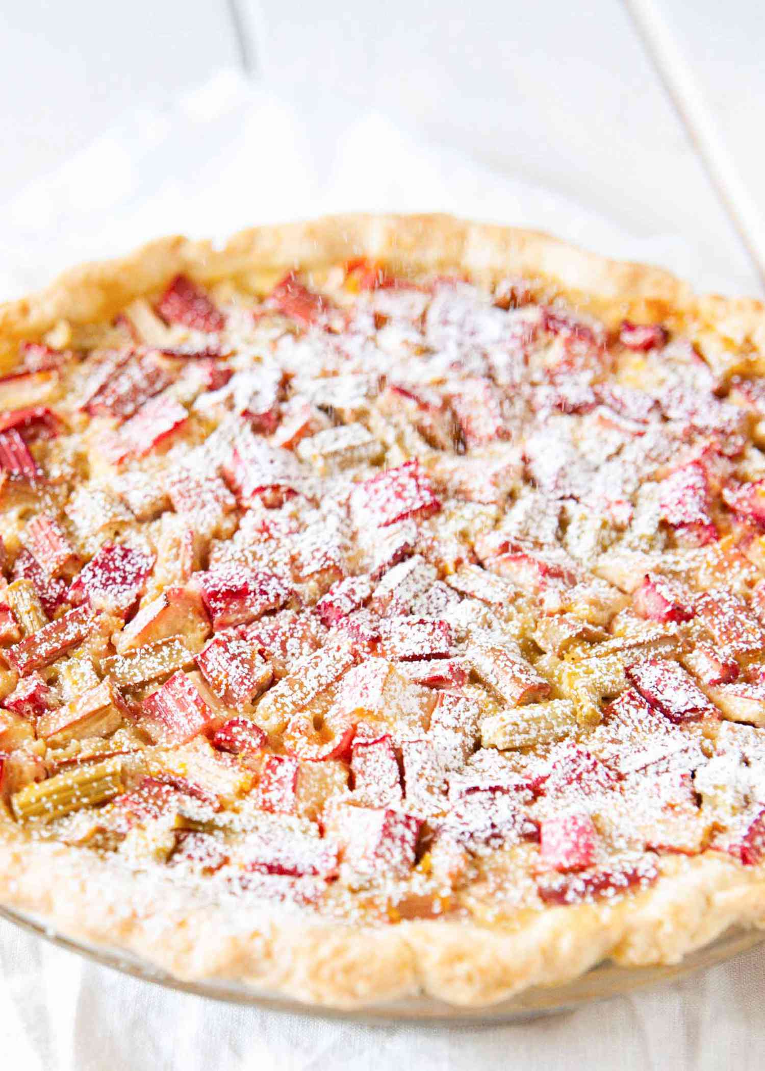 Best Rhubarb Pie Recipe - - rhubarb pie with powdered sugar on top