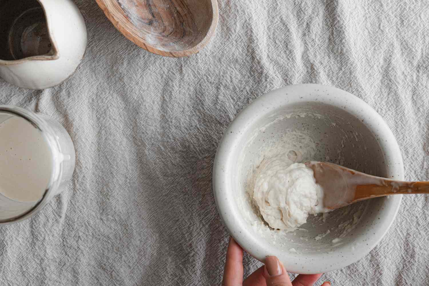 Overhead view of a small bowl and wooden spoon for a sourdough starter recipe