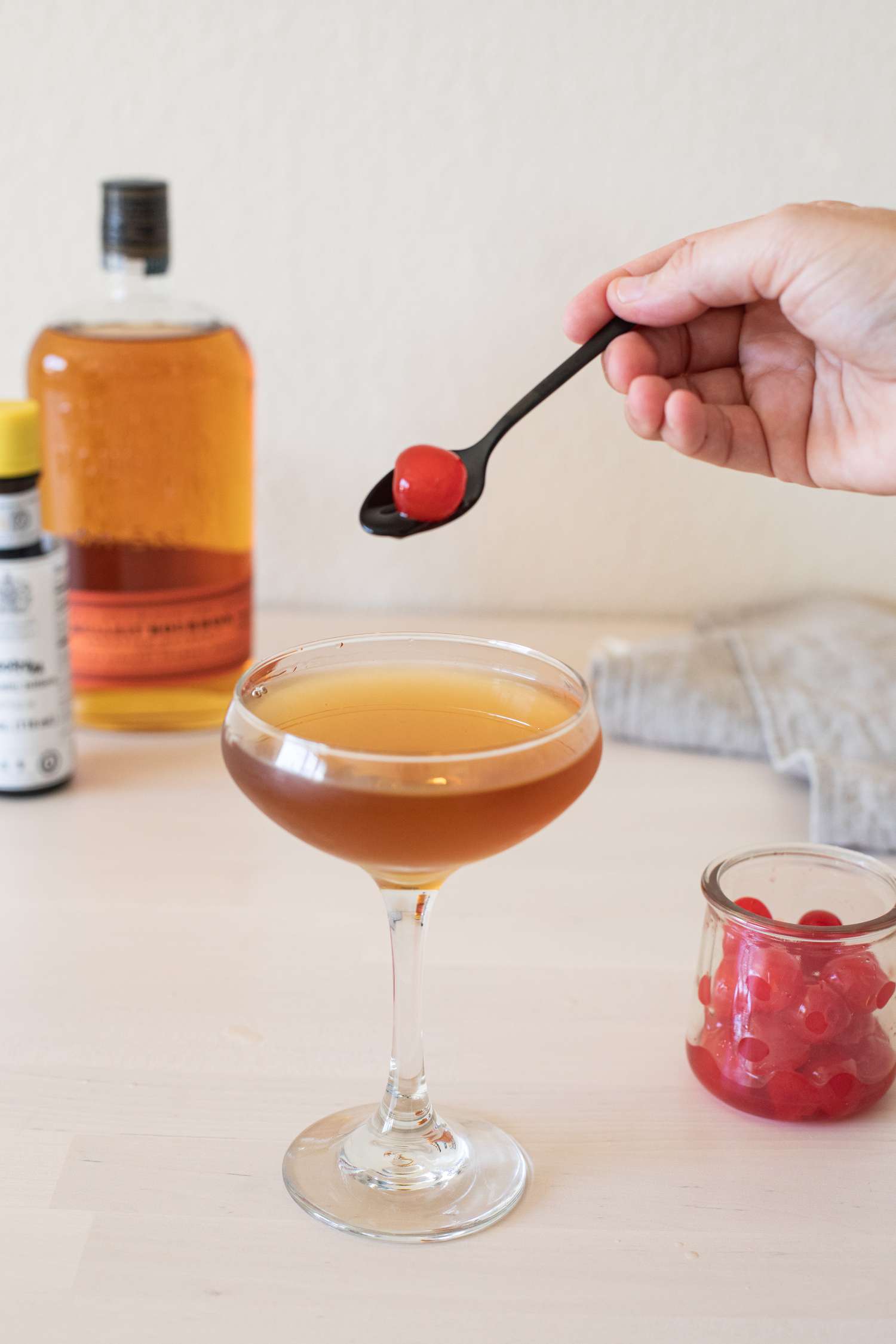 Adding a cherry to a cocktail
