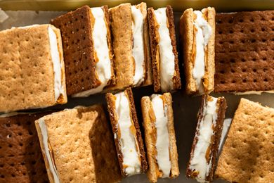 Several frozen graham cracker sandwiches filled with cream and peanut butter arranged on a surface