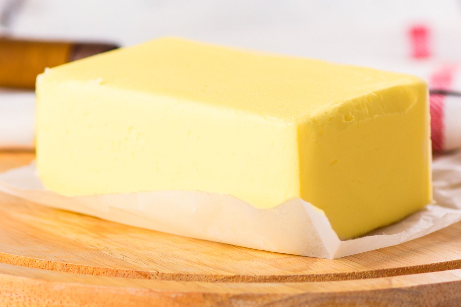 A close-up of a large block of butter on a piece of wax paper