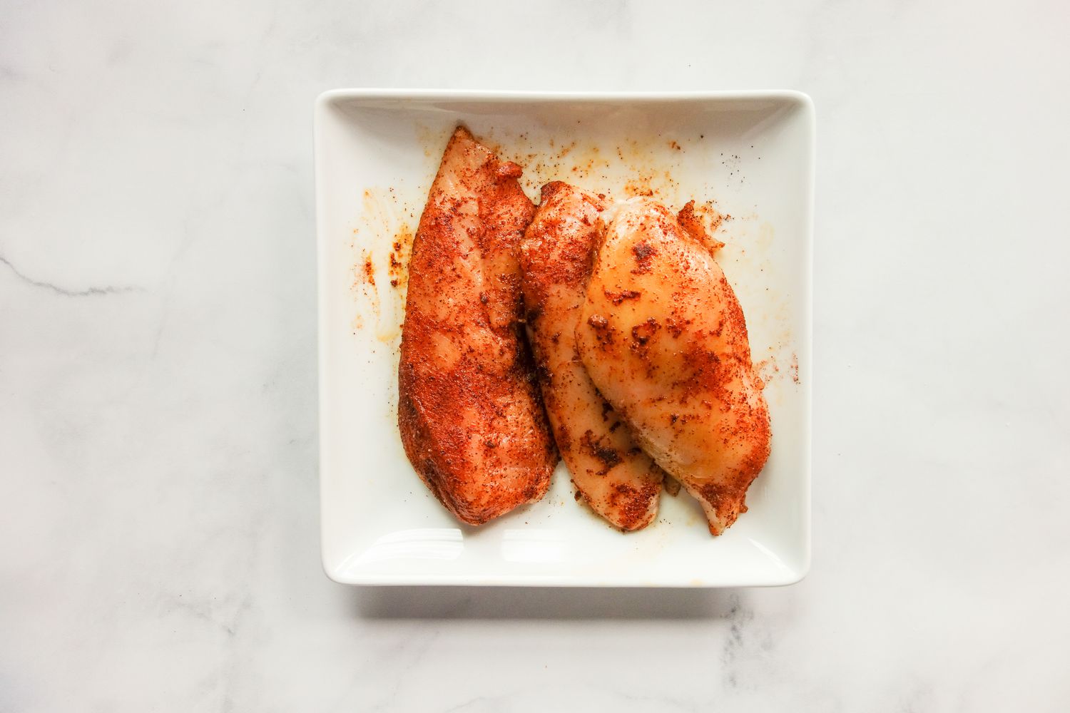 Seasoned chicken on plate.