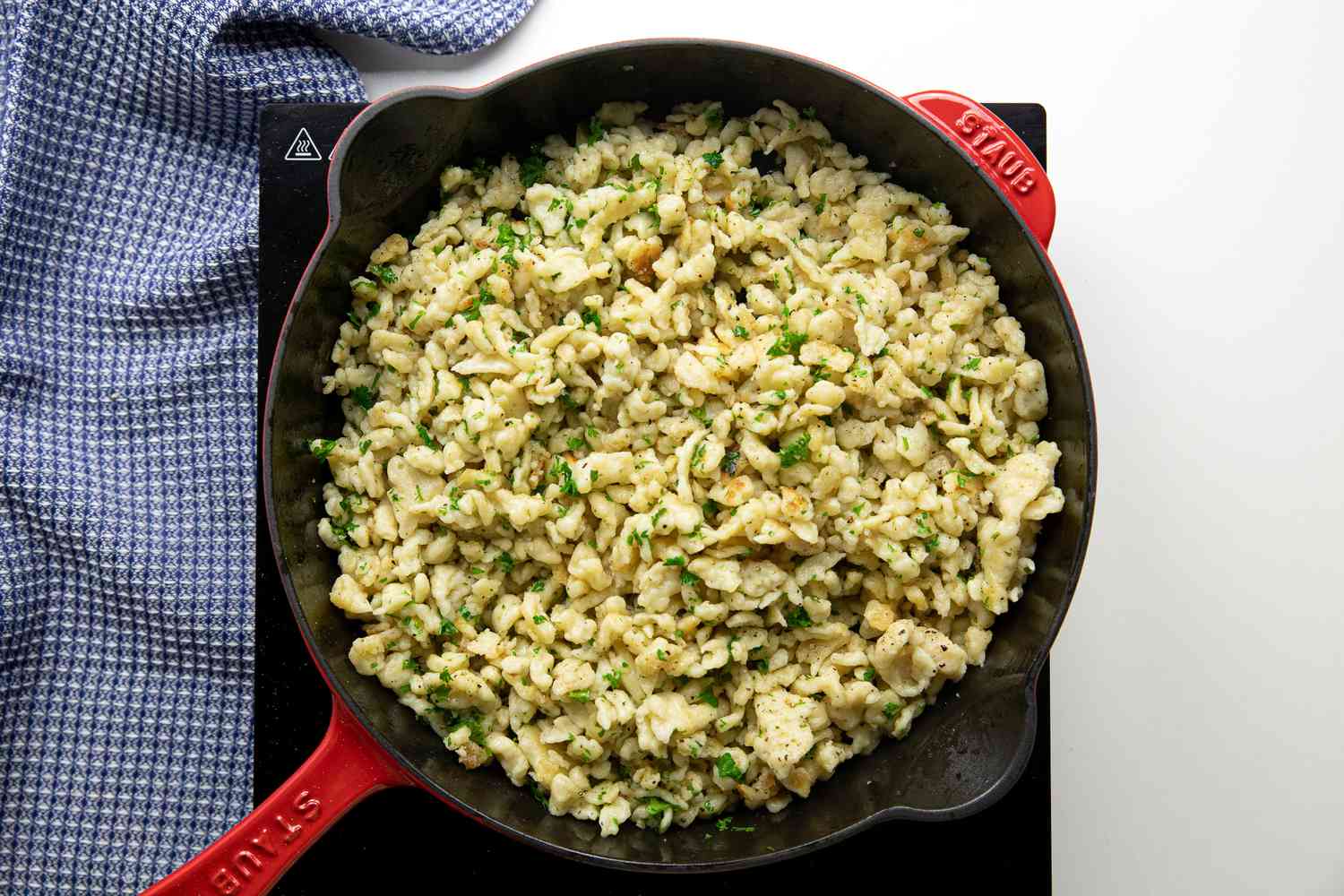 Homemade Spaetzle Added to Cast Iron Skillet and Seasoned 