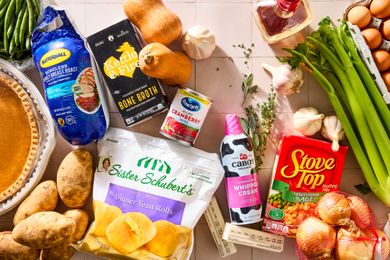 Assorted Thanksgiving food items including pie potatoes rolls cream and celery on a surface