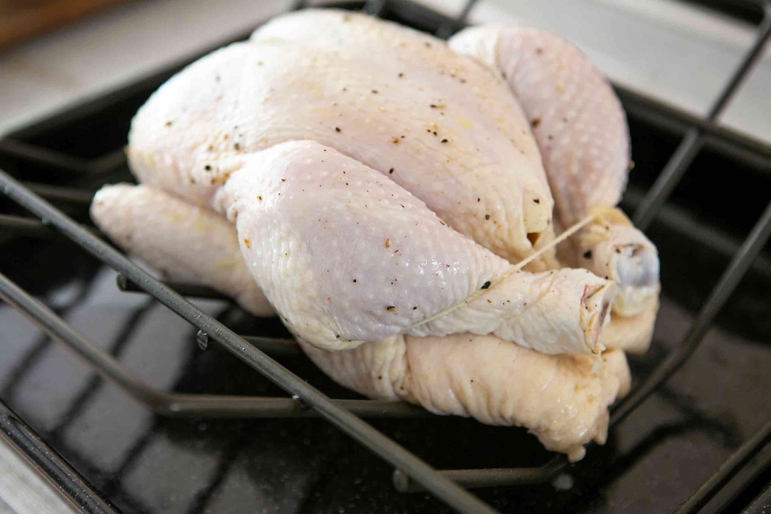 whole chicken trussed in roasting pan
