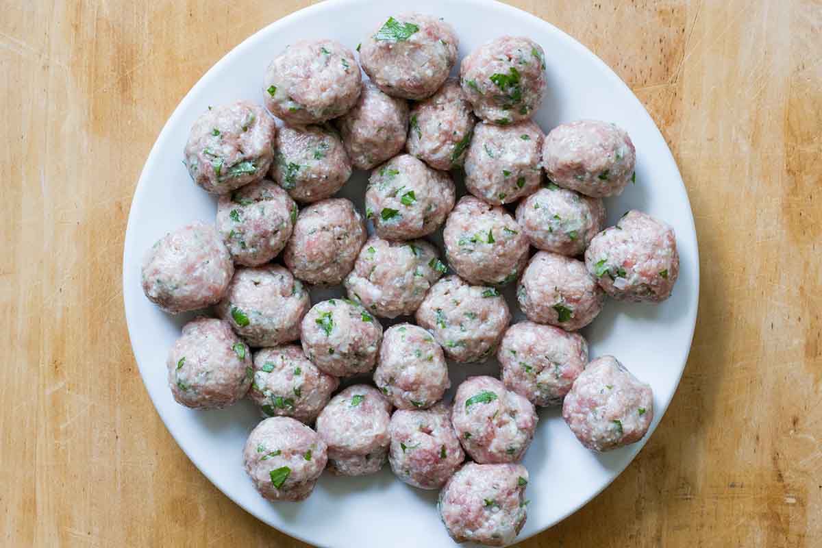 Authentic italian wedding soup meatballs formed and set on a plate.