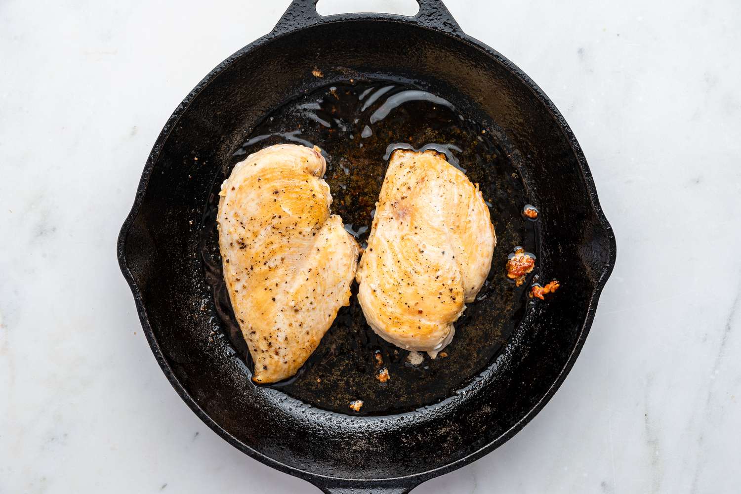 chicken breasts cooking in a cast iron skillet for chicken pomodoro recipe