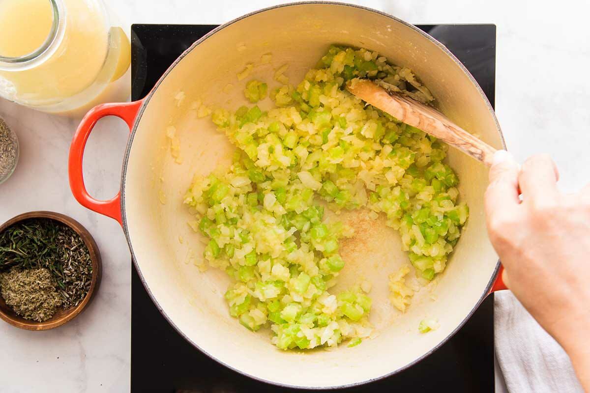 Vegetables are sauteed in a dutch oven to make a homemade Chicken Pot Pie.