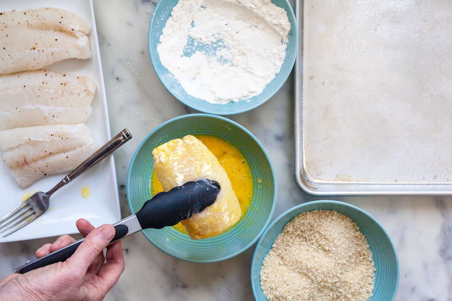 Fish fillet dipped in egg to make Fish Sandwiches with Avocado Mayo.