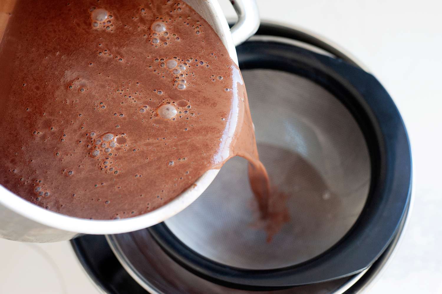Pouring the chocolate base into an ice cream maker to show how to make chocolate ice cream.
