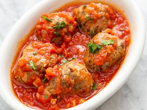 Turkey Meatballs in Tomato Sauce and Topped With Basil in a White Dish