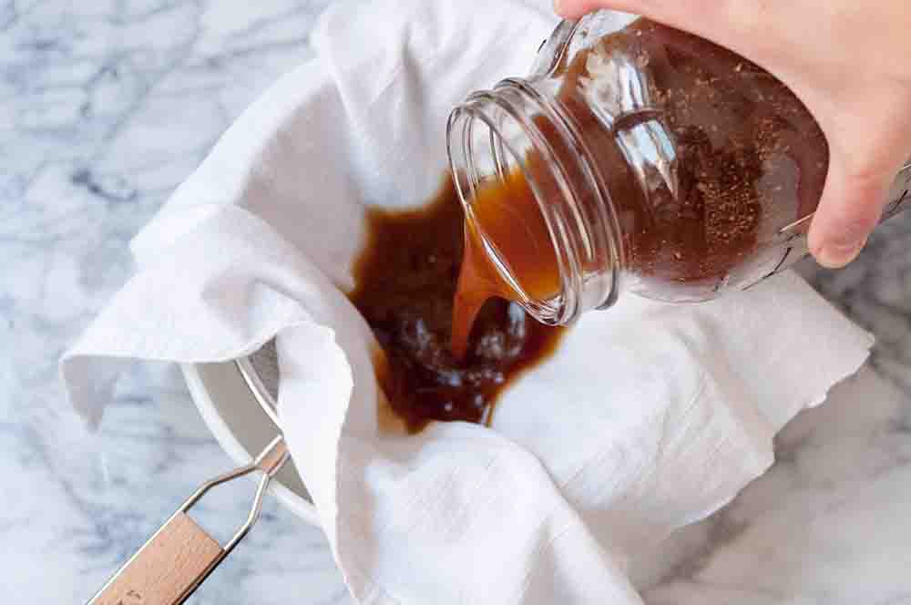 Coffee grounds mixture being strained through a cloth
