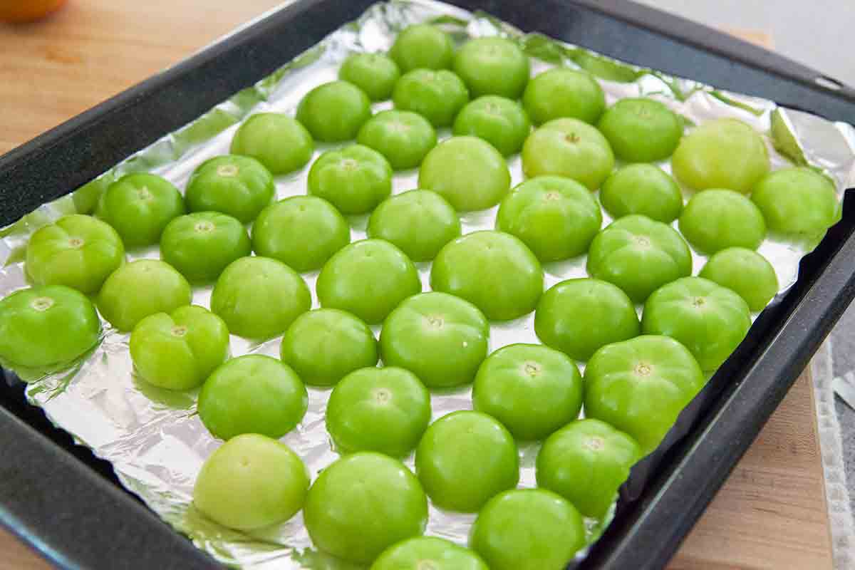 halved tomatillos cut side down on roasting tray