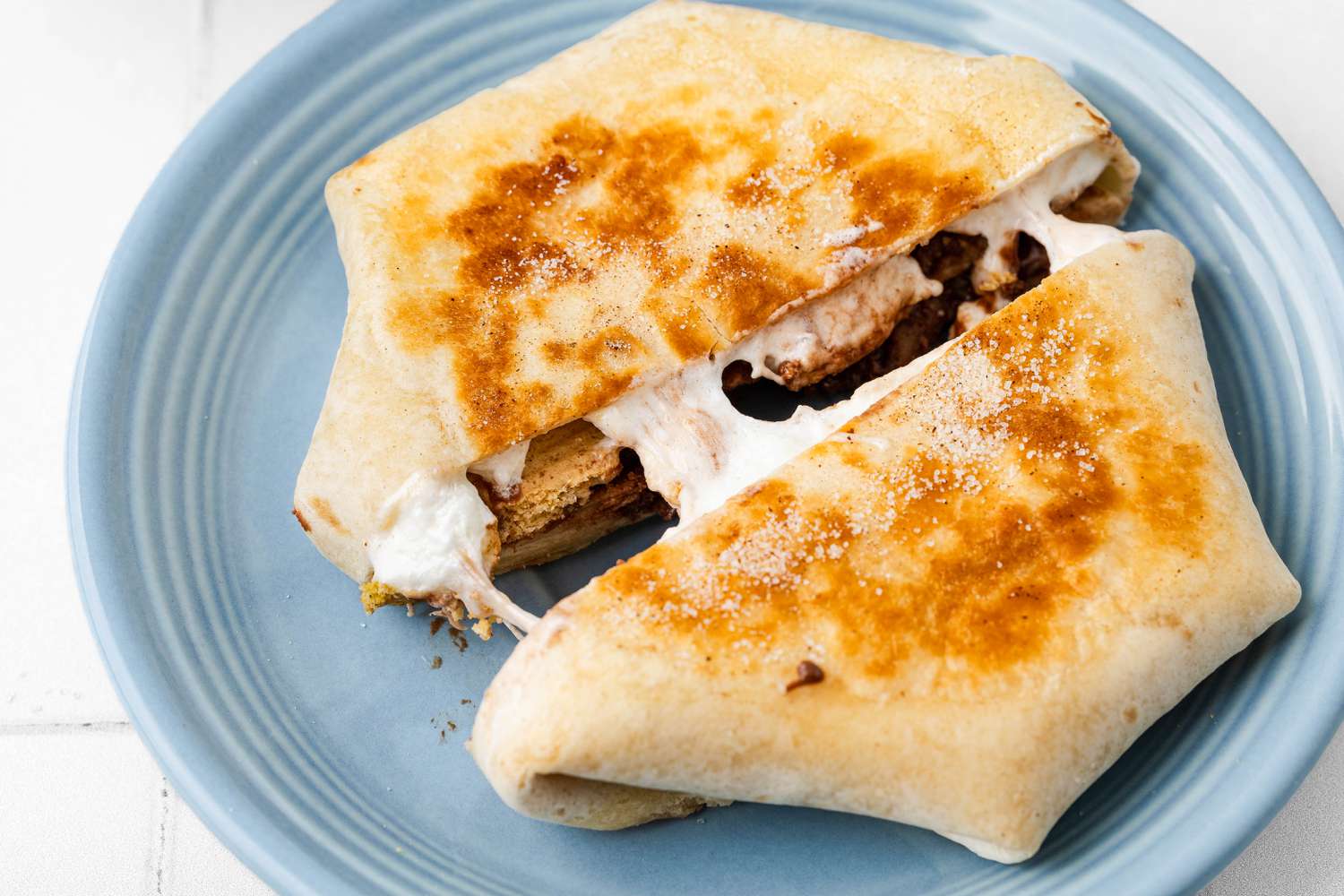 S'mores Crunchwrap Cut in Half on a Plate