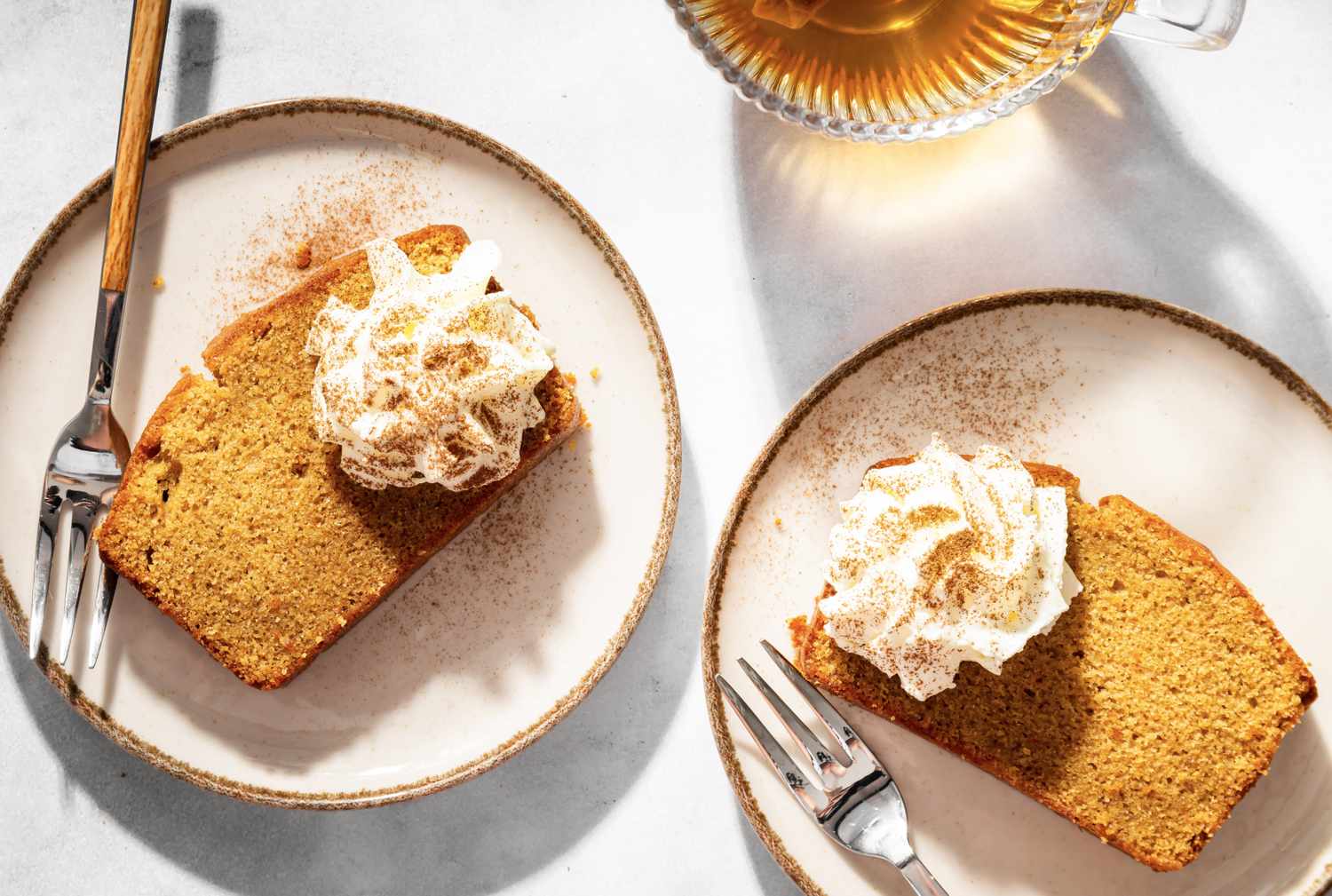Two plates of pound cake slices with whipped cream