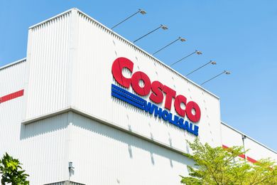 A Costco Wholesale sign on the exterior of a warehouse building viewed from a low angle