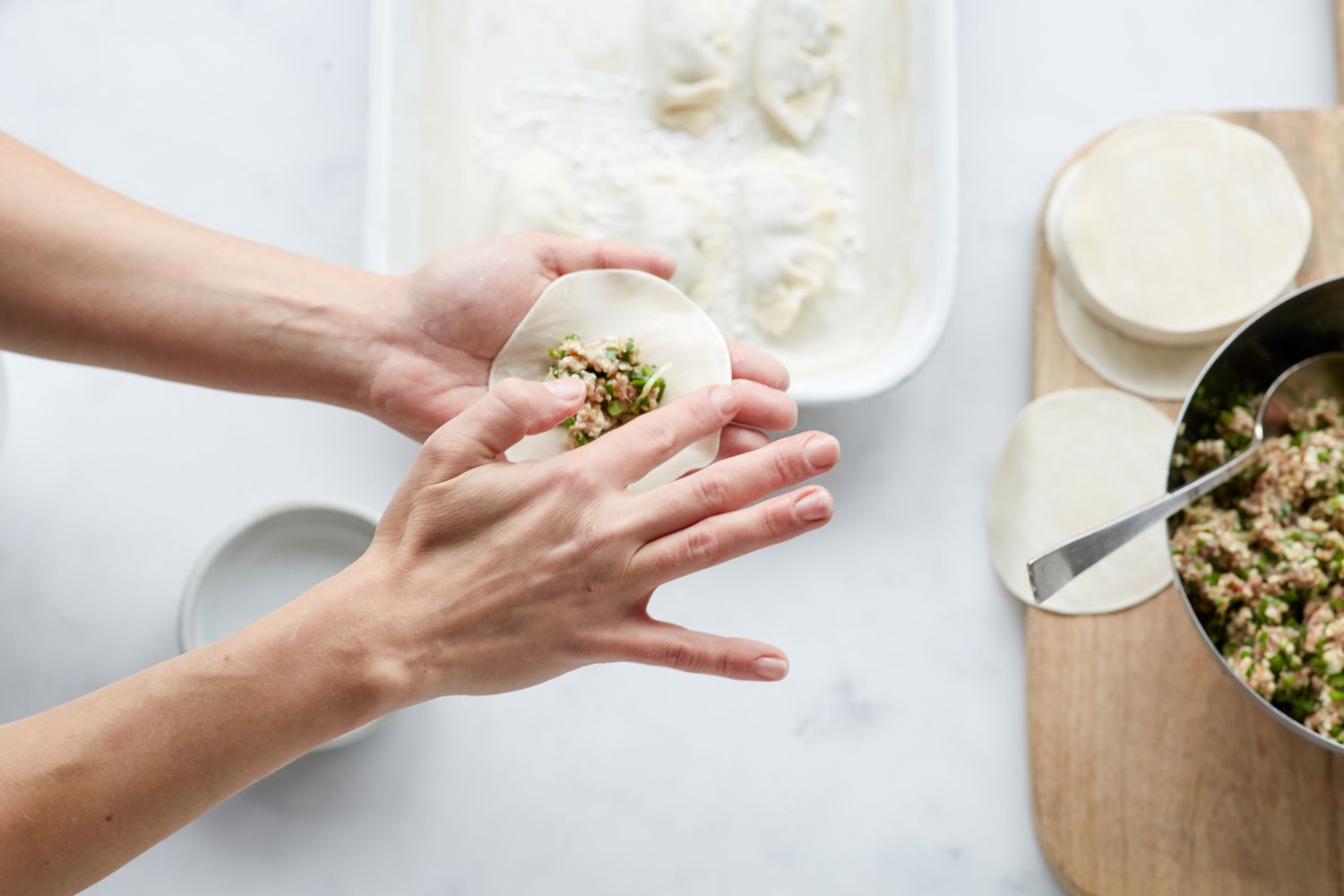 Filling and folding Korean pork and chives dumplings 