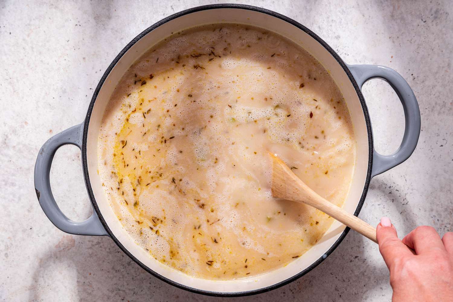 Broth and coconut milk stirred into the Dutch oven with seasoned stock vegetables for creamy vegetable dumpling soup recipe