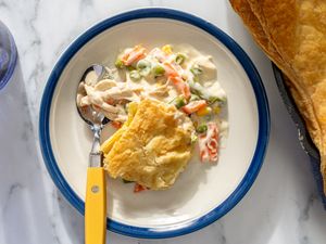 A plate containing chicken pot pie with a serving utensil nearby