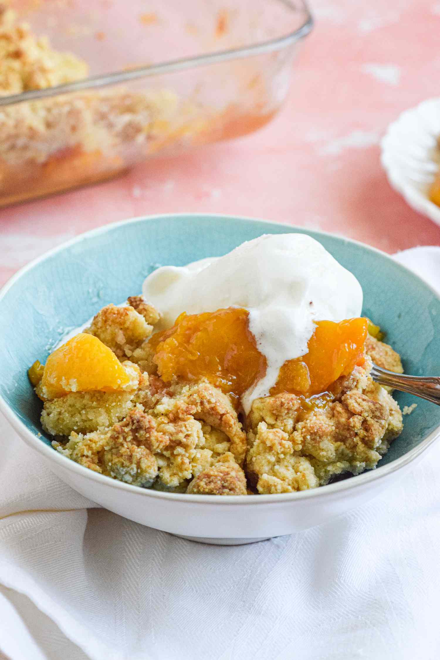 A Bowl of Peach Cobbler Topped with a Scoop of Vanilla Ice Cream