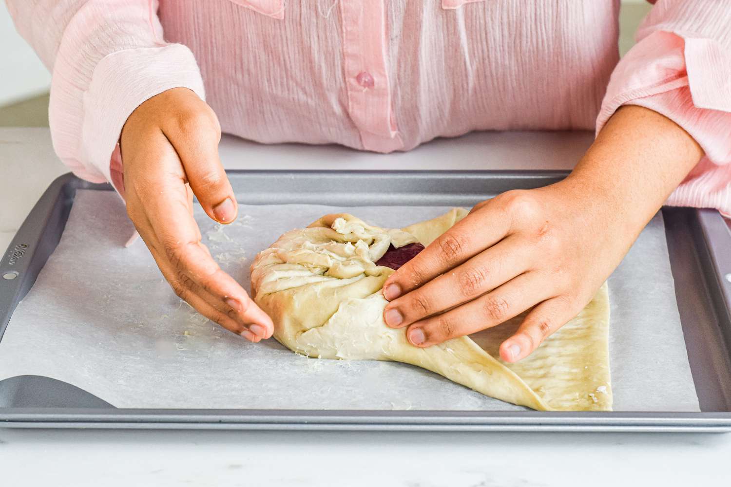 Wrapping brie in puff pastry to make baked brie with jam