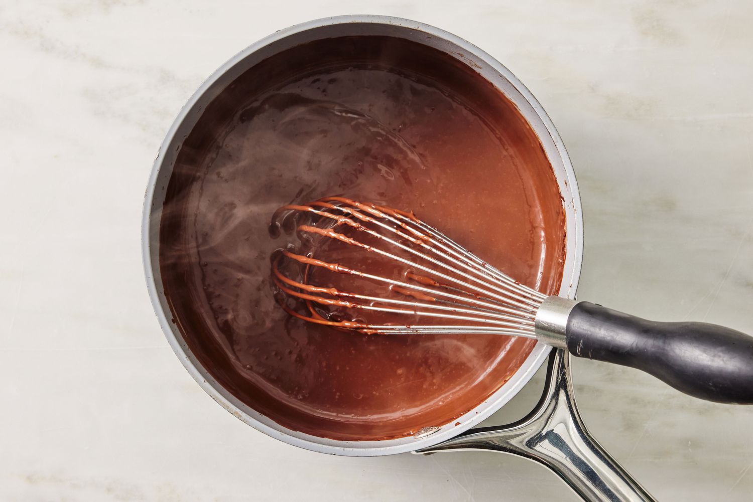 overhead view of chocolate cooking in a pot with a whisk for Arkansas Possum Pie recipe