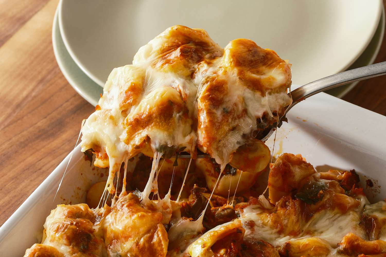 Close up shot of a cheesy spoonful of tortellini casserole