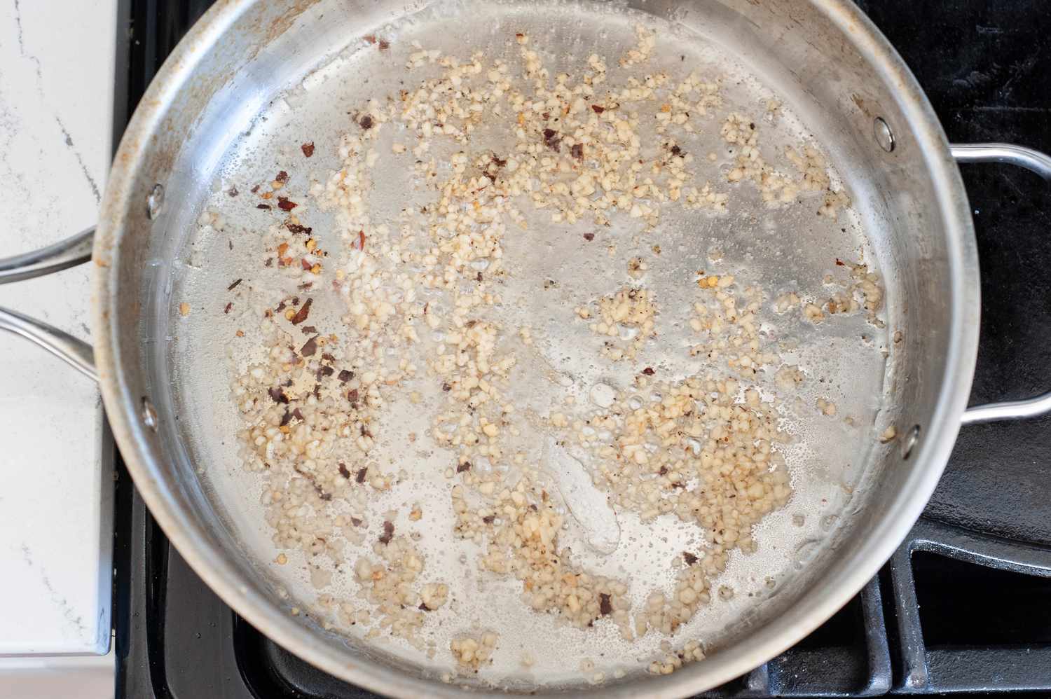 Toast Garlic and Chili Peppers in Skillet on Stove for Penne alla Vodka