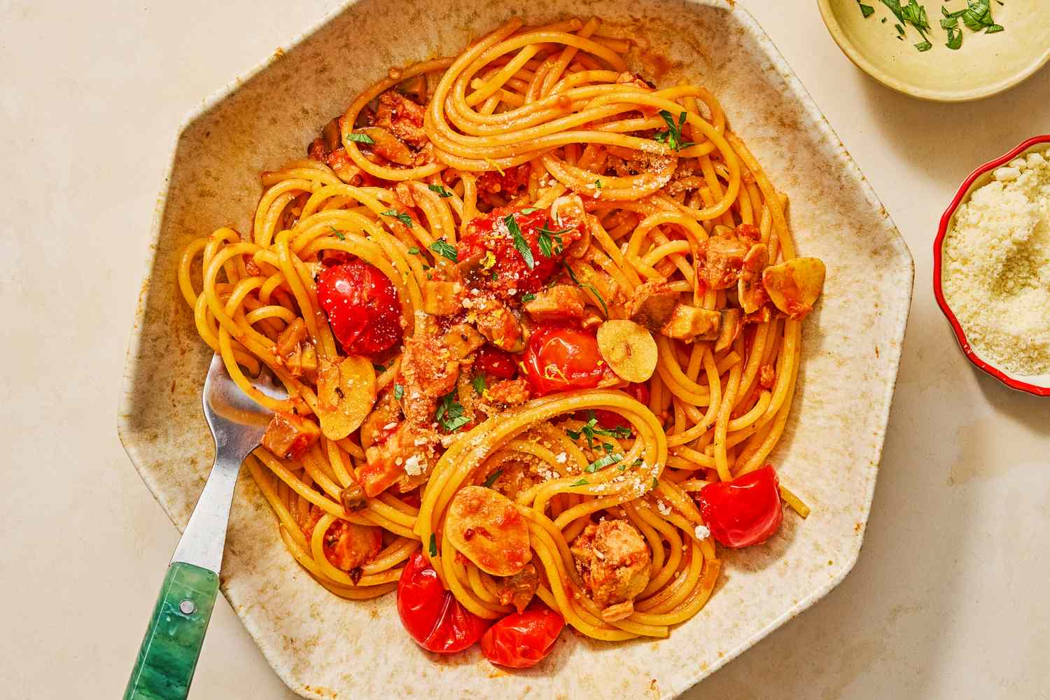 A plated serving of spaghetti alla carrettiera with cherry tomatoes and garnishes on a table