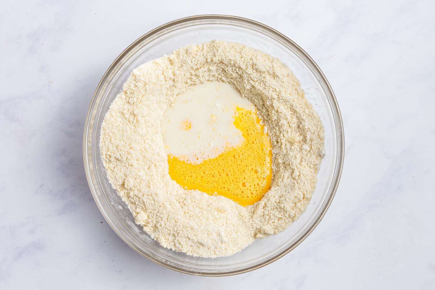 Liquid ingredients added to a glass bowl to make the topping for a blackberry cobbler recipe.