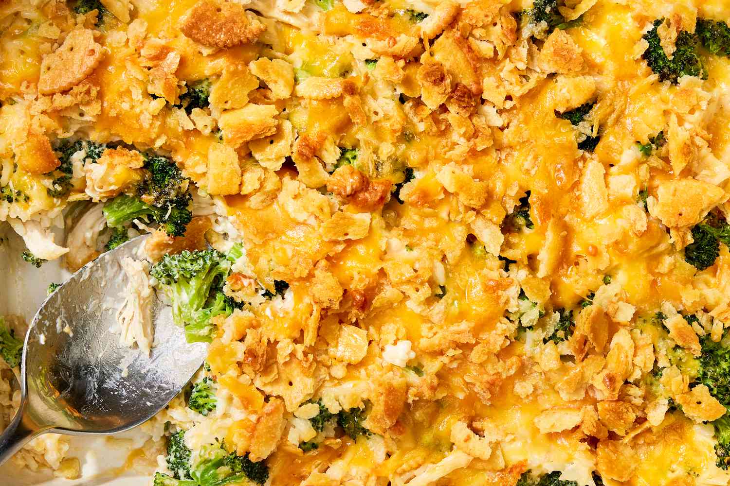 Closeup view of a chicken and broccoli casserole and a serving spoon