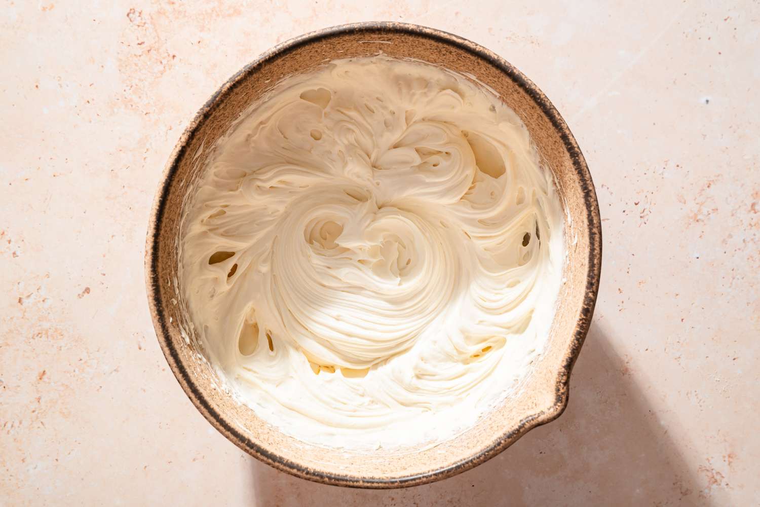 Overhead view of a bowl of cream cheese, powdered sugar, vanilla, and salt whipped for Chocolate Delight recipe
