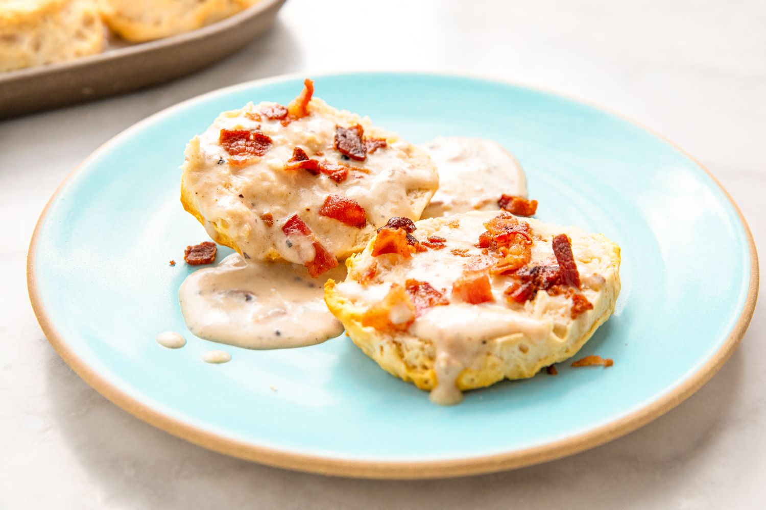 Biscuits with gravy and bacon pieces served on a plate