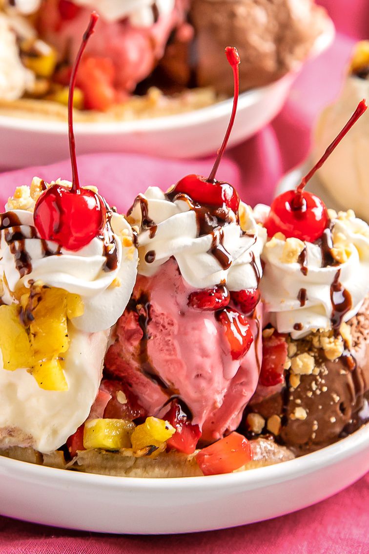 Close-up of Grilled Banana Split Topped With Chocolate Sauce, Peanuts, Whipped Cream, and Three Maraschino Cherries in a Banana Split Dish