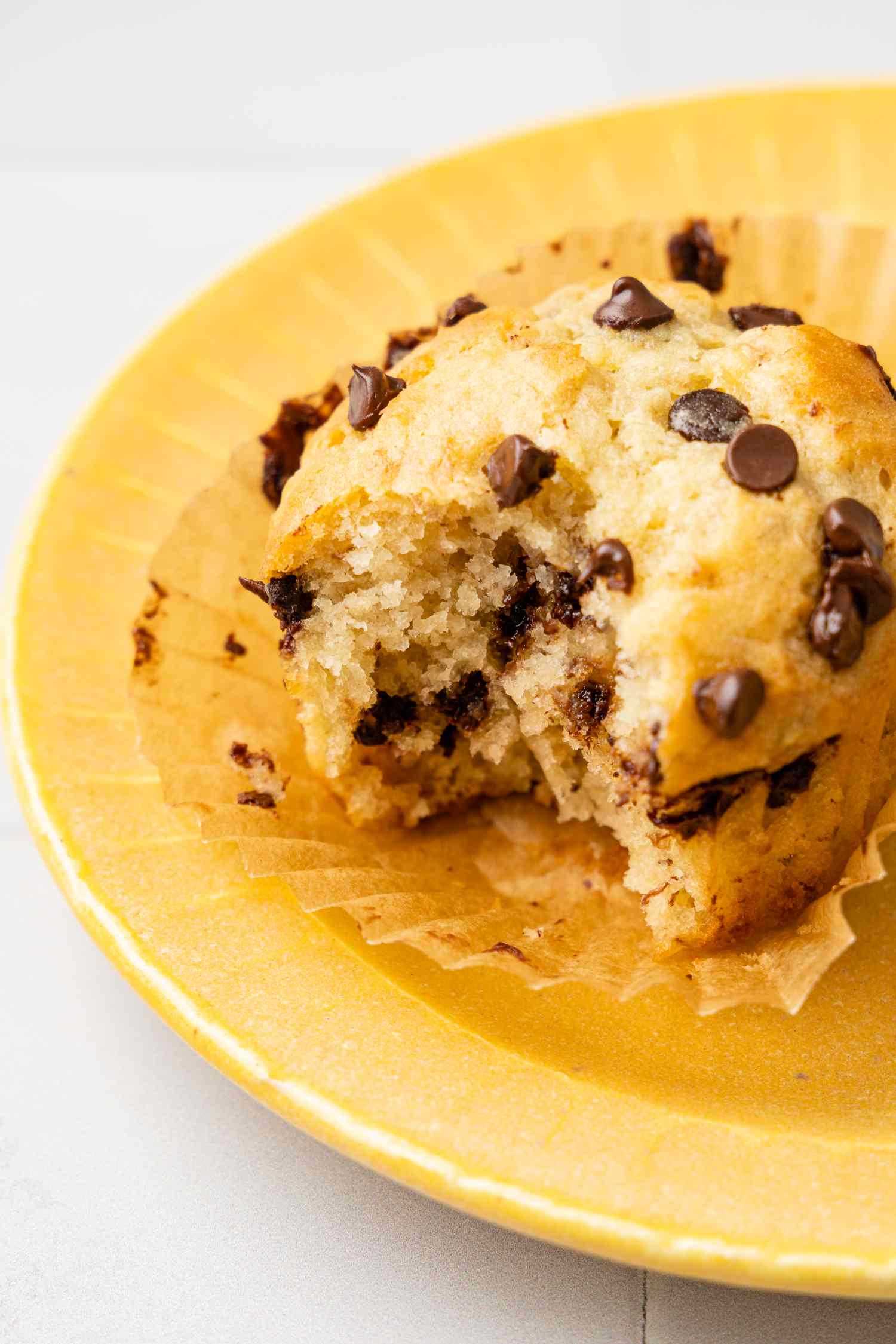 A Banana Chocolate Chip Muffin Bitten Into on a Plate