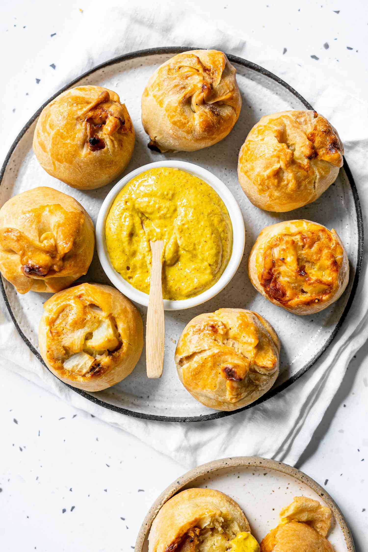 Potato Knishes on a Plate with a Bowl of Mustard